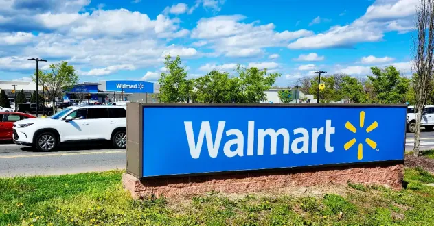 Walmart sign in front of the store with car driving by