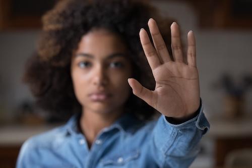 Close up focus African woman show palm hand opposes racial or gender discrimination, make stop gesture, sign of protest, female against domestic violence, abortion, bullying at school, say no concept