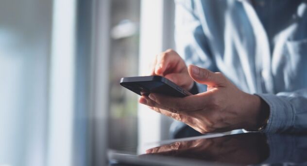 close up business woman using mobile smart phone on glass