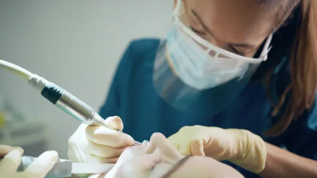 dentist performing surgical procedure on patient in a dental chair